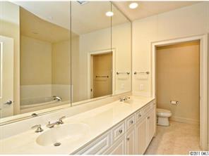 435 South Tryon Street, Unit 704 Charlotte, NC 28202 - Photo 11 of 13 a bathroom with a double vanity sink mirror double and shower