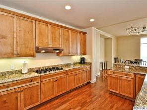 435 South Tryon Street, Unit 704 Charlotte, NC 28202 - Photo 5 of 13 a large kitchen with stainless steel appliances granite countertop a sink stove and cabinets