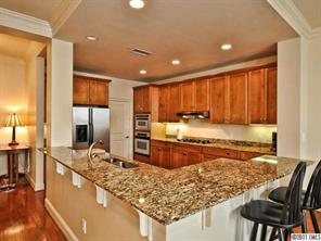 435 South Tryon Street, Unit 704 Charlotte, NC 28202 - Photo 6 of 13 a large kitchen with kitchen island granite countertop wooden cabinets a granite counter tops and a large window