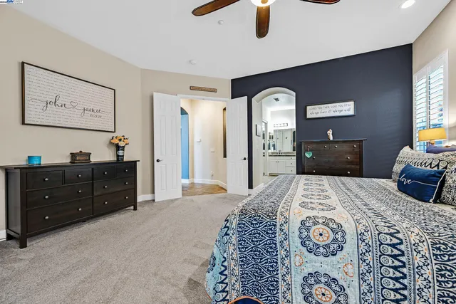 a spacious bedroom with a bed and a dresser