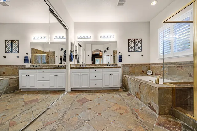 a large kitchen with stainless steel appliances a stove sink and cabinets