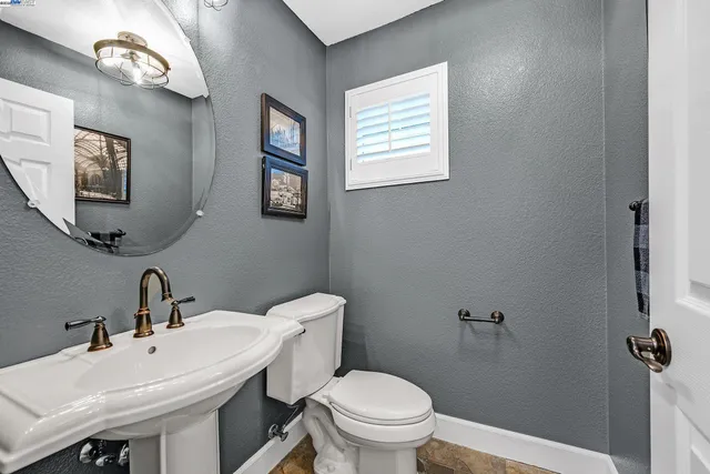 a bathroom with a sink a toilet and mirror