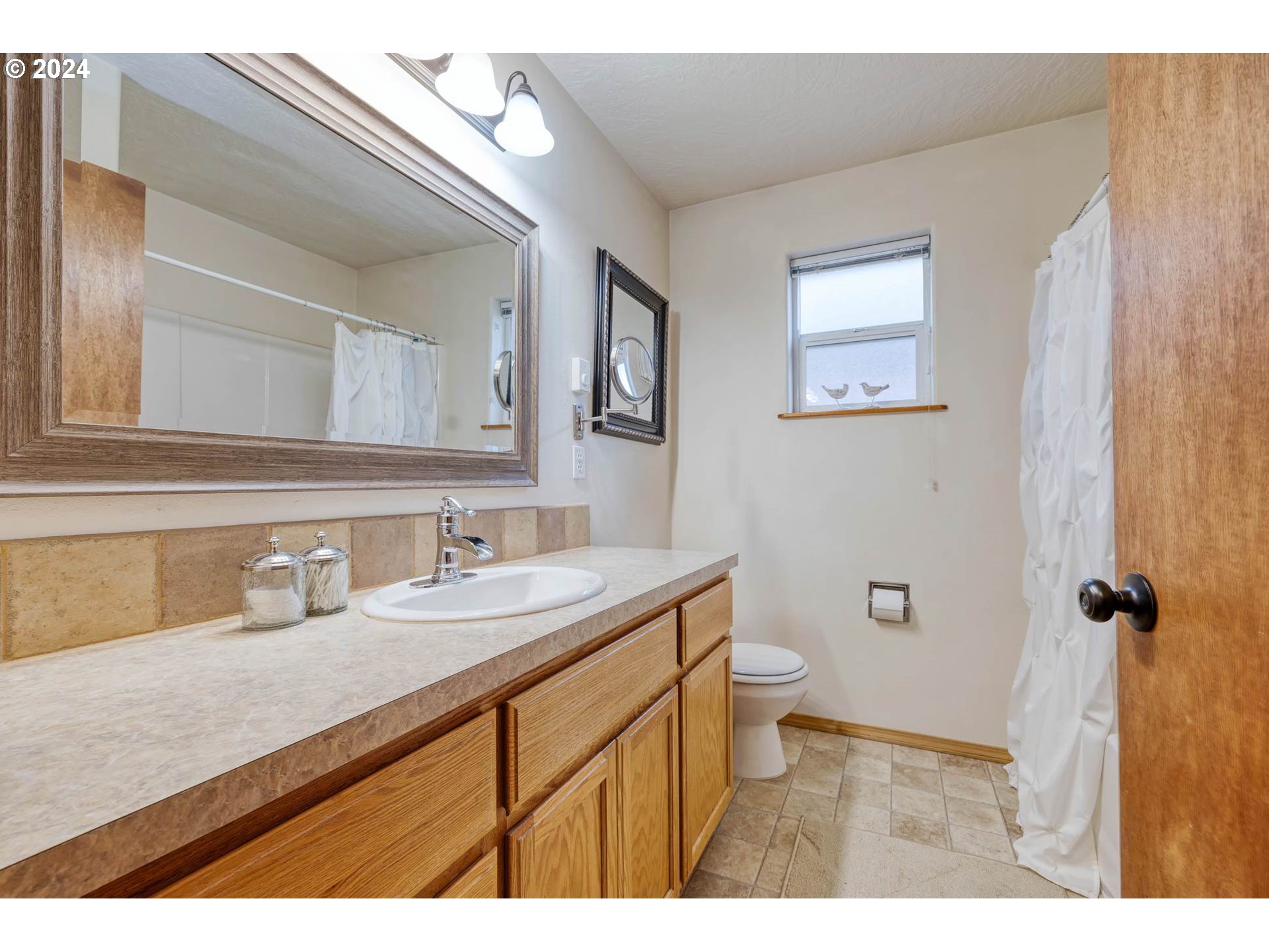 4850 A Street Springfield, OR 97478 - Photo 30 of 40 a bathroom with a granite countertop sink a toilet and a mirror