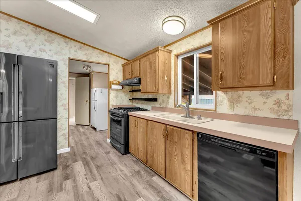 a kitchen with stainless steel appliances granite countertop a refrigerator and a sink
