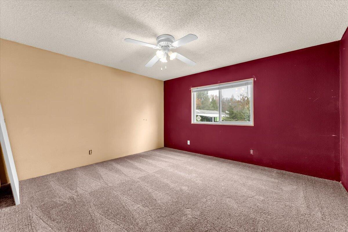 1237 Mountain Shadows Boulevard Redding, CA 96003 - Photo 24 of 34 an empty room with windows and fan