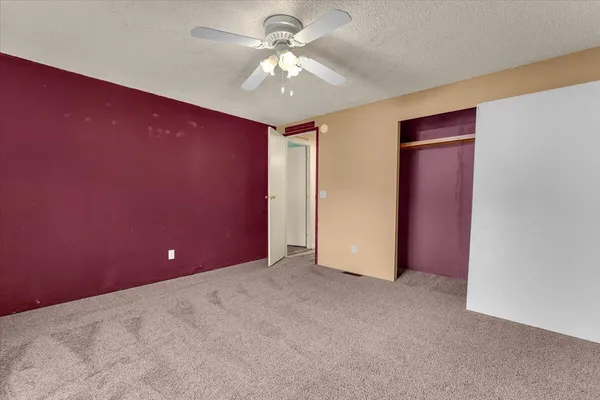 an empty room with window and ceiling fan