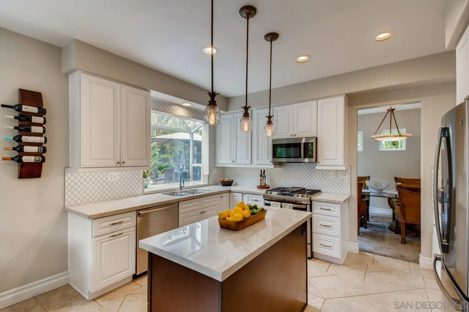 11468 Village Ridge Road San Diego, CA 92131 - Photo 9 of 28 a kitchen with a sink a counter top space stainless steel appliances and cabinets