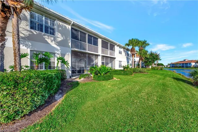 an aerial view of residential houses with outdoor space and lake view