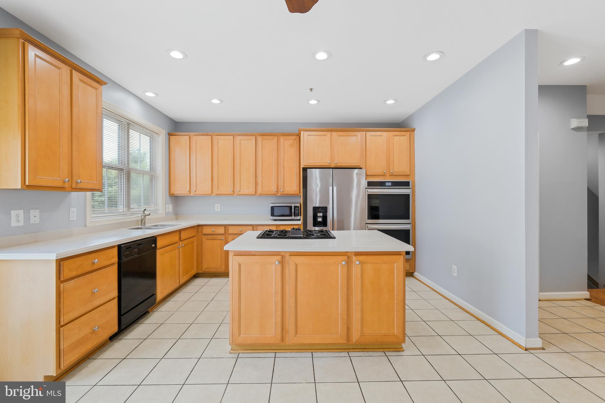 10728 Horde Street Silver Spring, MD 20902 - Photo 6 of 38 a kitchen with stainless steel appliances granite countertop a stove a sink and a refrigerator
