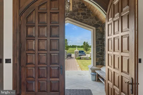 a kitchen with granite countertop a refrigerator a sink and white cabinets