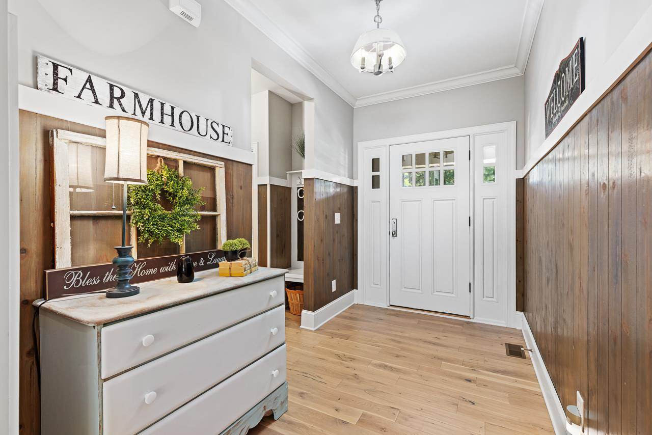 Wide open foyer with crown moldings and custom wainscoting. Foyer