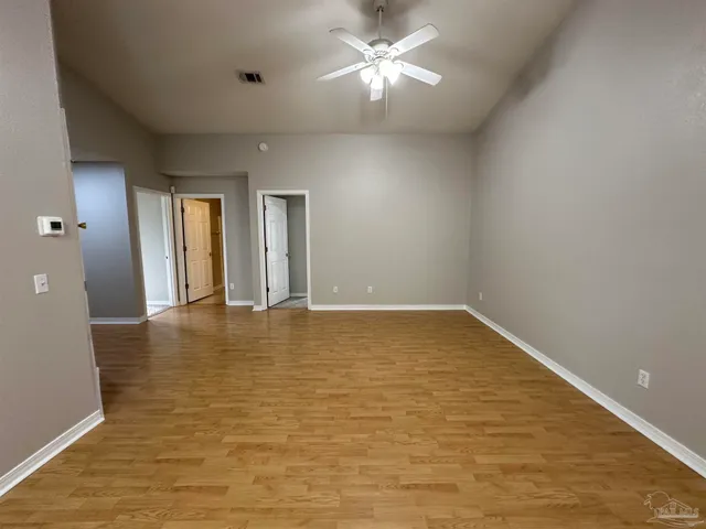 a view of empty room with wooden floor