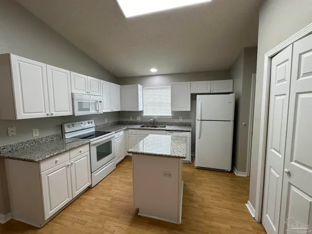 a kitchen with a refrigerator sink and cabinets