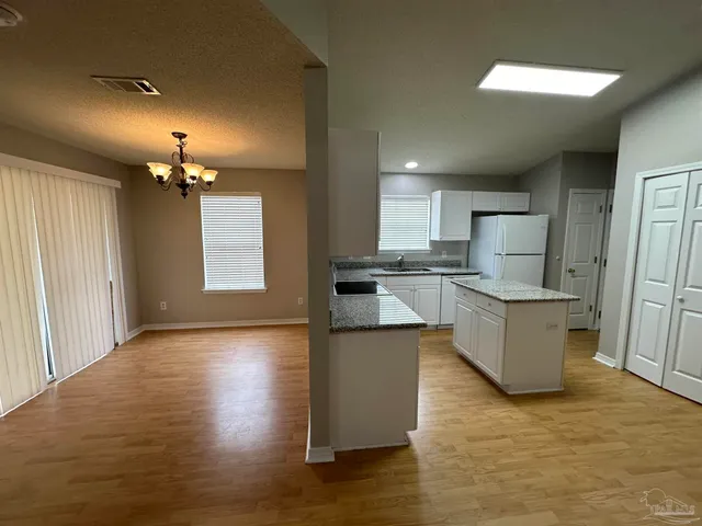 a kitchen with kitchen island refrigerator sink and stove
