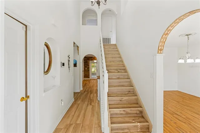 a view of a hallway with wooden floor and staircase