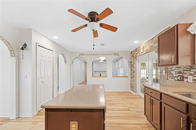 a view of a kitchen with granite countertop cabinets a sink and stainless steel appliances