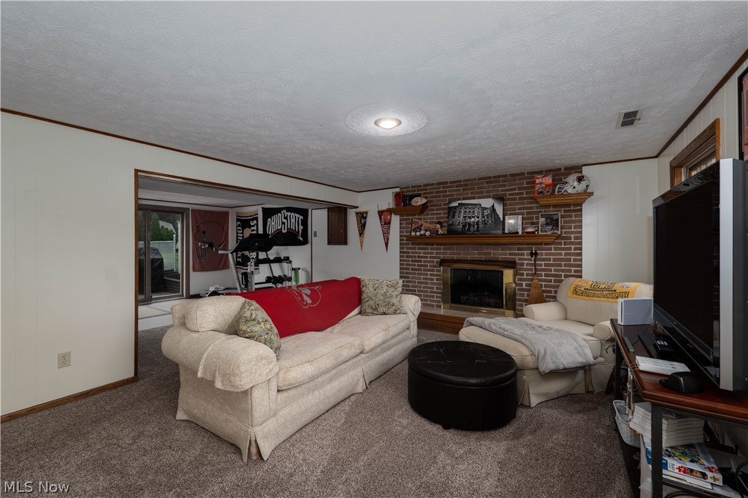 1619 Reed Street Canal Fulton, OH 44614 - Photo 22 of 27 Recessed lighting, brick fireplace, wood mantel, and sliding glass door