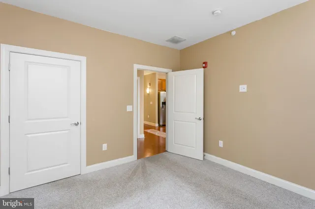an empty room with closet and wooden door