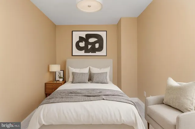 a bedroom with a bed and a painting on the wall
