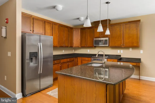 a kitchen with stainless steel appliances granite countertop a sink refrigerator and microwave