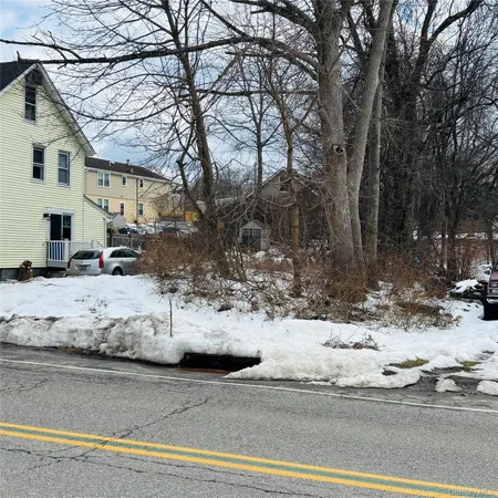 a view of white house with snow on the road