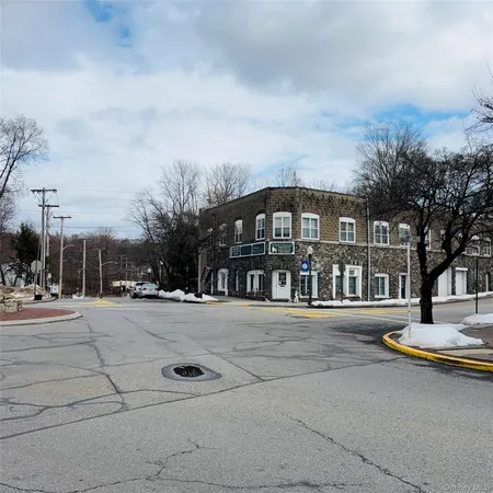 a view of residential building with cars parked on road
