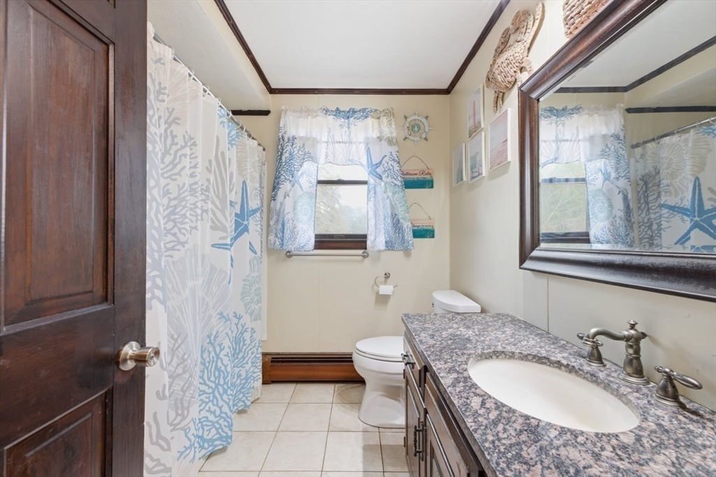 64 Village Street Millis, MA 02054 - Photo 31 of 41 a bathroom with a granite countertop sink a mirror a toilet and a shower