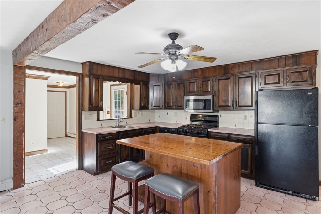 64 Village Street Millis, MA 02054 - Photo 6 of 41 a kitchen with a table chairs refrigerator and cabinets