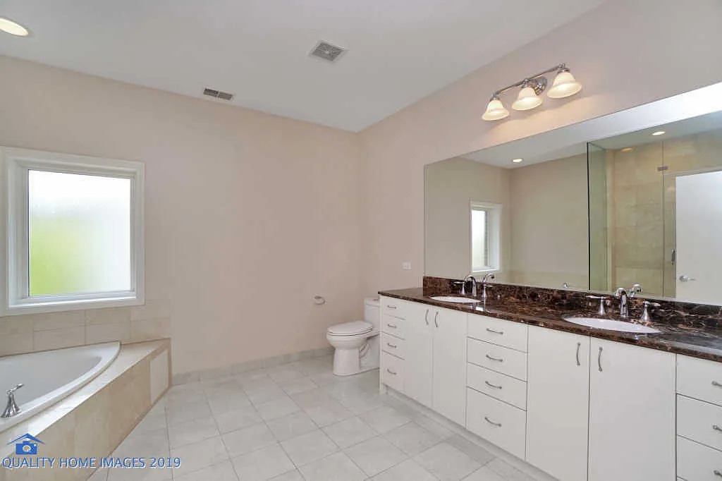 1501 South Prairie Avenue, Unit 1 Chicago, IL 60605 - Photo 16 of 23 a spacious bathroom with a granite countertop double vanity sink a mirror and a bathtub