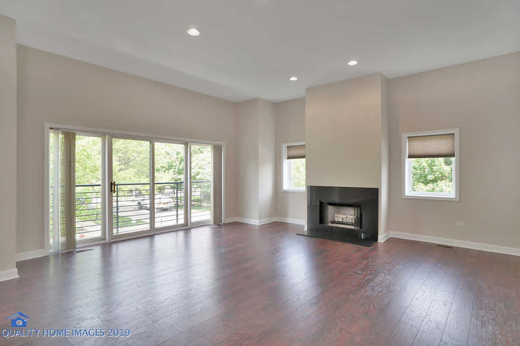 1501 South Prairie Avenue, Unit 1 Chicago, IL 60605 - Photo 5 of 23 an empty room with windows a fireplace and wooden floor