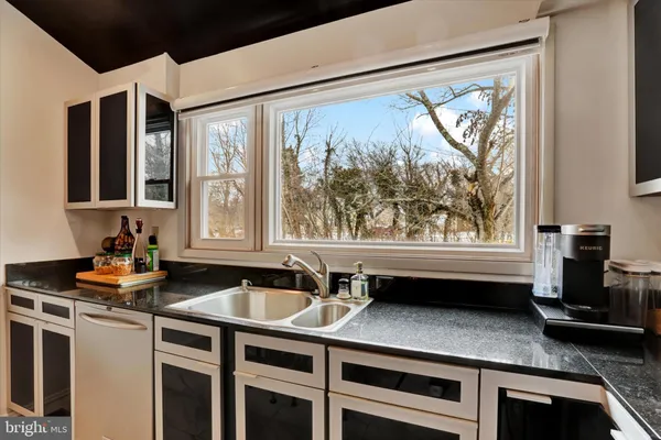 a kitchen with stainless steel appliances granite countertop a stove top oven a sink a dining table and chairs