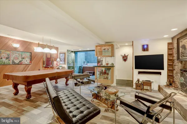a living room with couch piano table and a chandelier