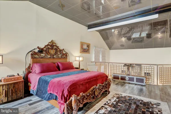 a bedroom with a bed mirror and a window