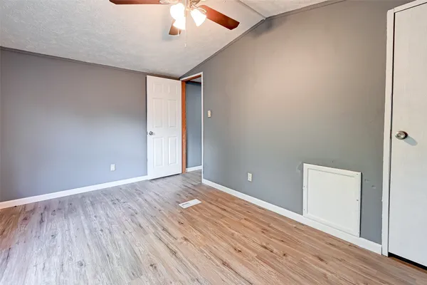 a view of an empty room with wooden floor