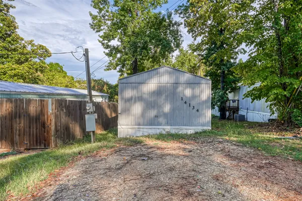 a view of a tiny house with a yard and large trees