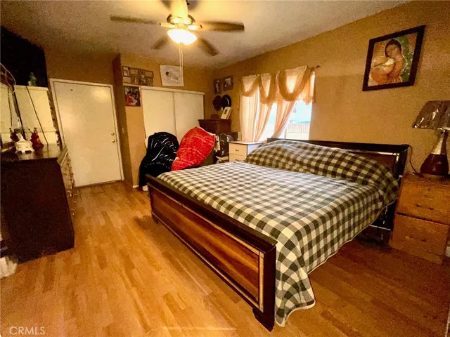 a bedroom with a bed and wooden floor