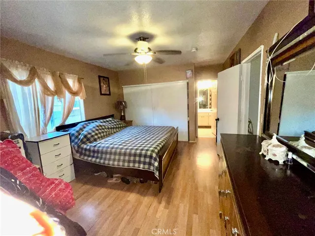 a spacious bedroom with a bed and wooden floor