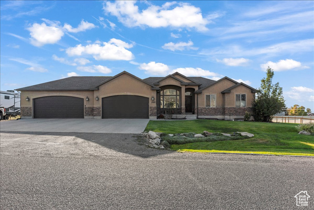 3949 Rose Springs Road Erda, UT 84074 - Photo 1 of 1 View of front facade featuring stucco siding, a front lawn, an attached garage, and driveway