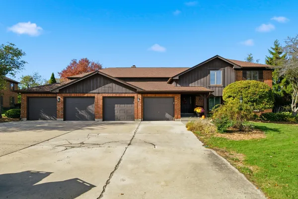 a front view of a house with a garden and yard