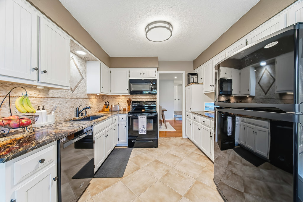 90 Golfview Lane, Unit D Frankfort, IL 60423 - Photo 13 of 27 a kitchen with granite countertop a stove top oven and cabinets
