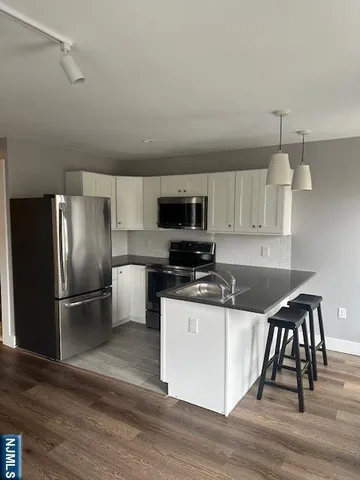 a kitchen with granite countertop a refrigerator a stove a sink and a microwave