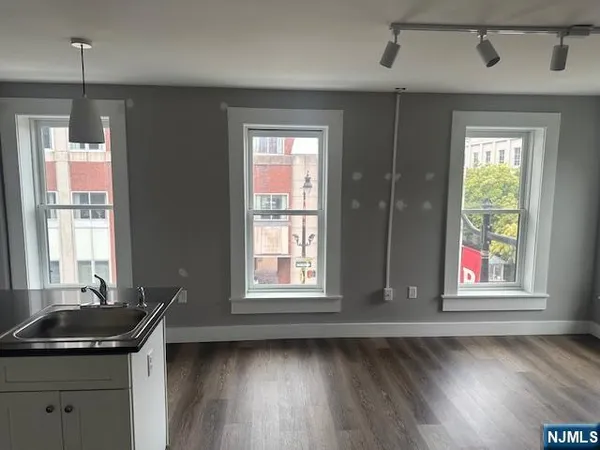 a room with wooden floor and windows