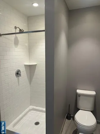 a white toilet sitting next to a bath tub and shower