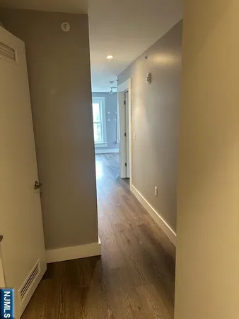 a view of a hallway with wooden floor
