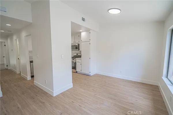 a view of empty room with wooden floor