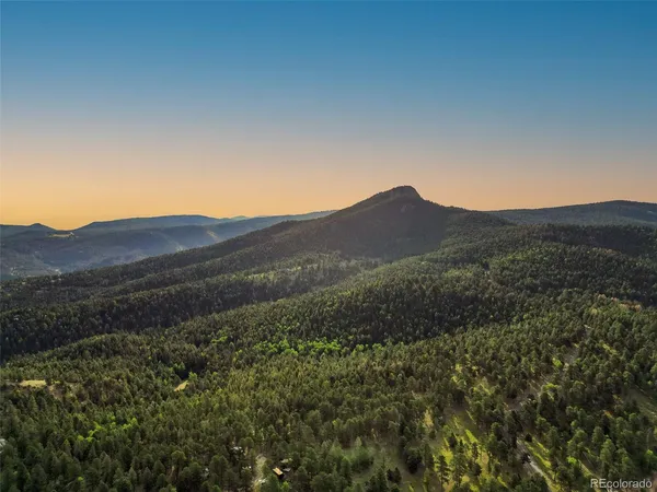 a view of a mountain range with a lush green hillside