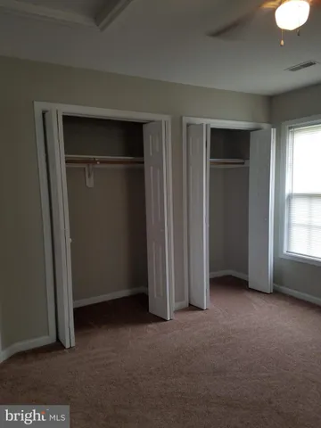an empty room with closet and windows