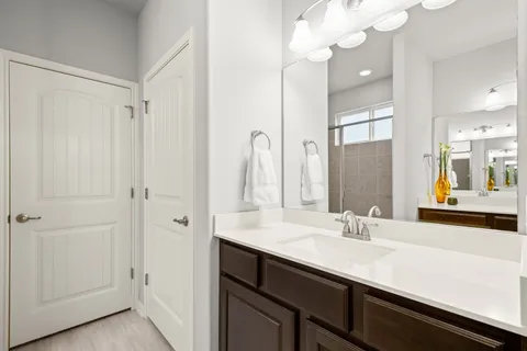 a bathroom with a double vanity sink a mirror and shower