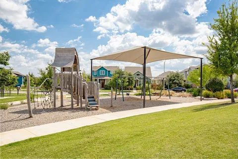 a view of a swimming pool with a lawn chairs under an umbrella
