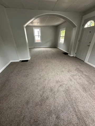 an empty room with a fireplace and windows